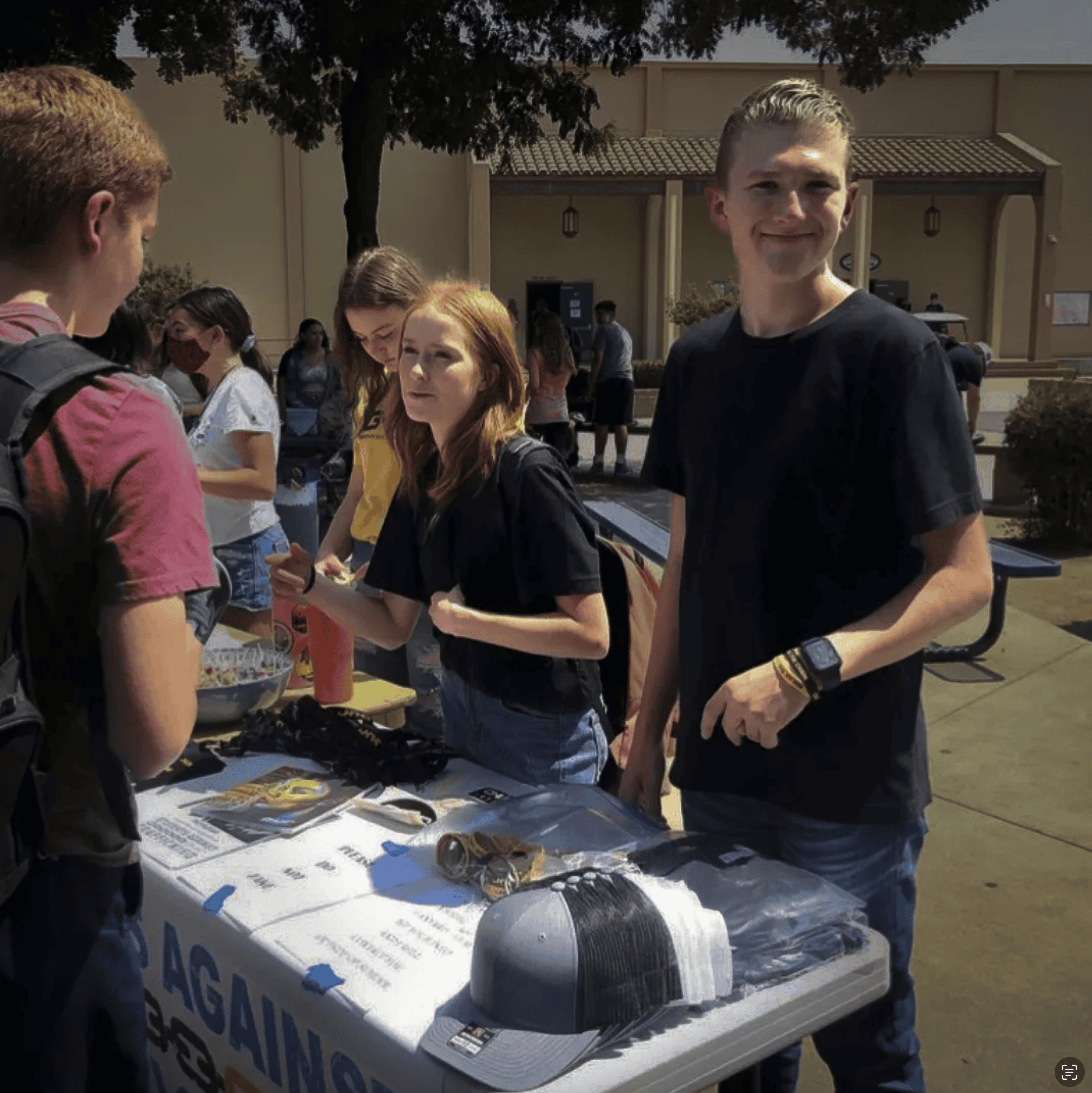 A group of students talk at an OUR Rescue awareness booth