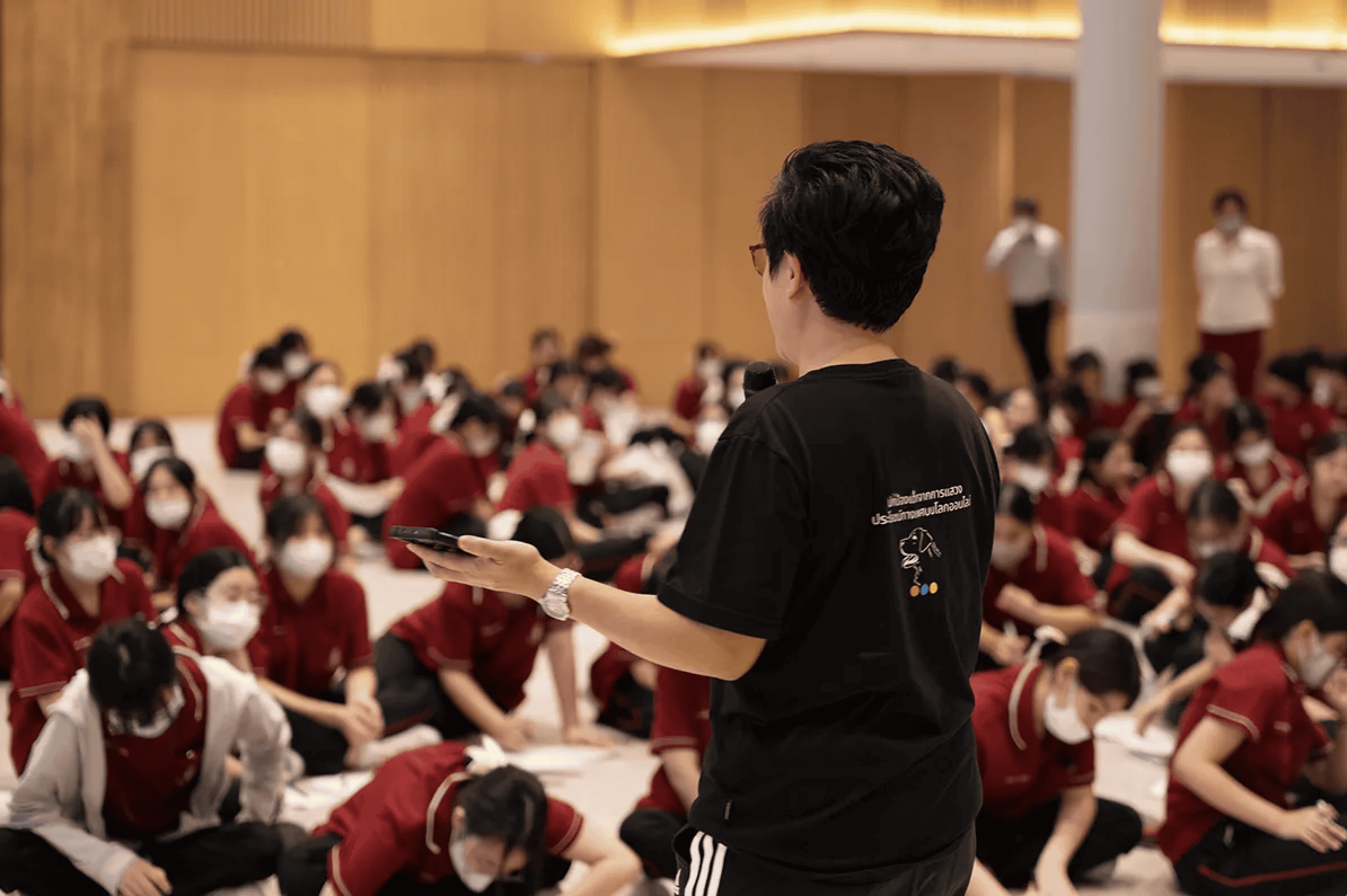 A man speaks to a room of students in Thailand