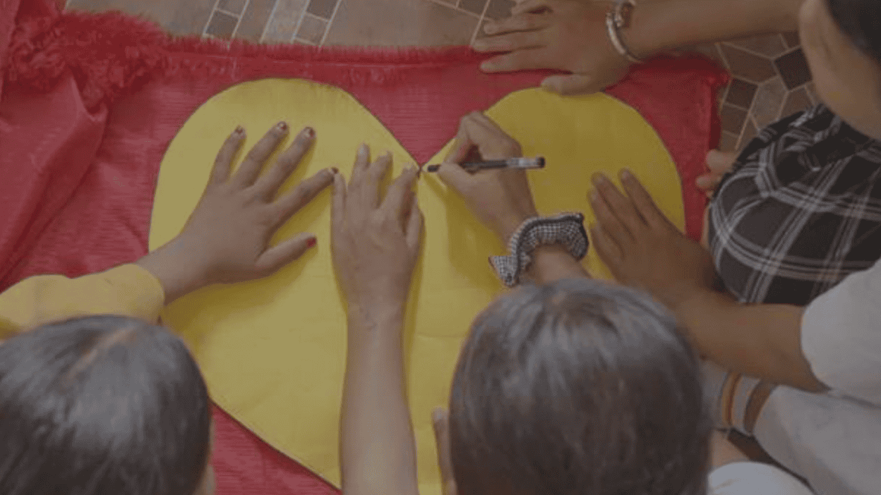 group of kids drawing on a paper heart